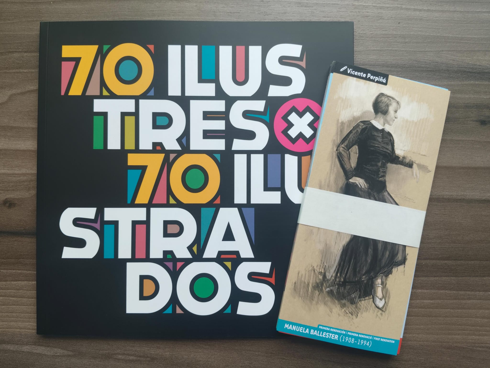 Catálogo 70 Il·lustres x 70 Il·lustrats junto a la tarjeta de la reinterpretación de Manuela Ballester realizada por Vicente Perpiñá