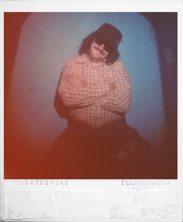 Vicente Perpiñá caracterizado como Gianni Markel con sombrero y gafas oscuras, en una fotografía tipo Polaroid